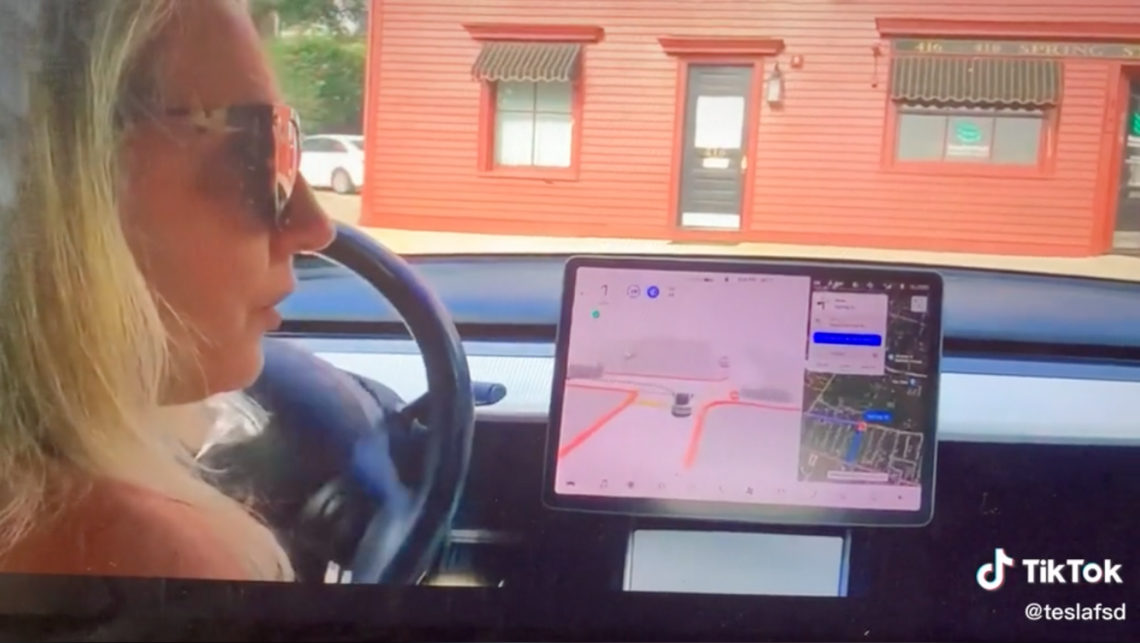 A TikTok screenshot showing a woman in sunglasses behind the wheel of a Tesla in full self-driving mode.